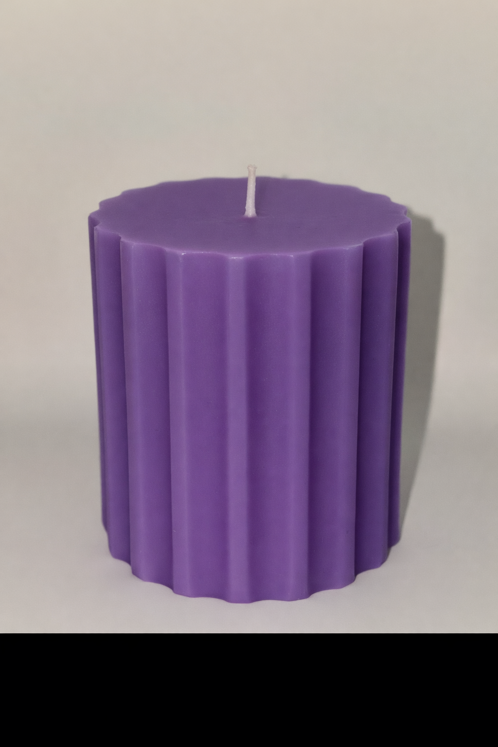 Ribbed cylinder pillar candle in purple, white, and yellow with soy wax and aromatherapy scents