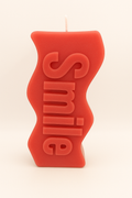 Red Smile Candle with cheerful smile design, bold red color, and warm cozy ambiance for home decor